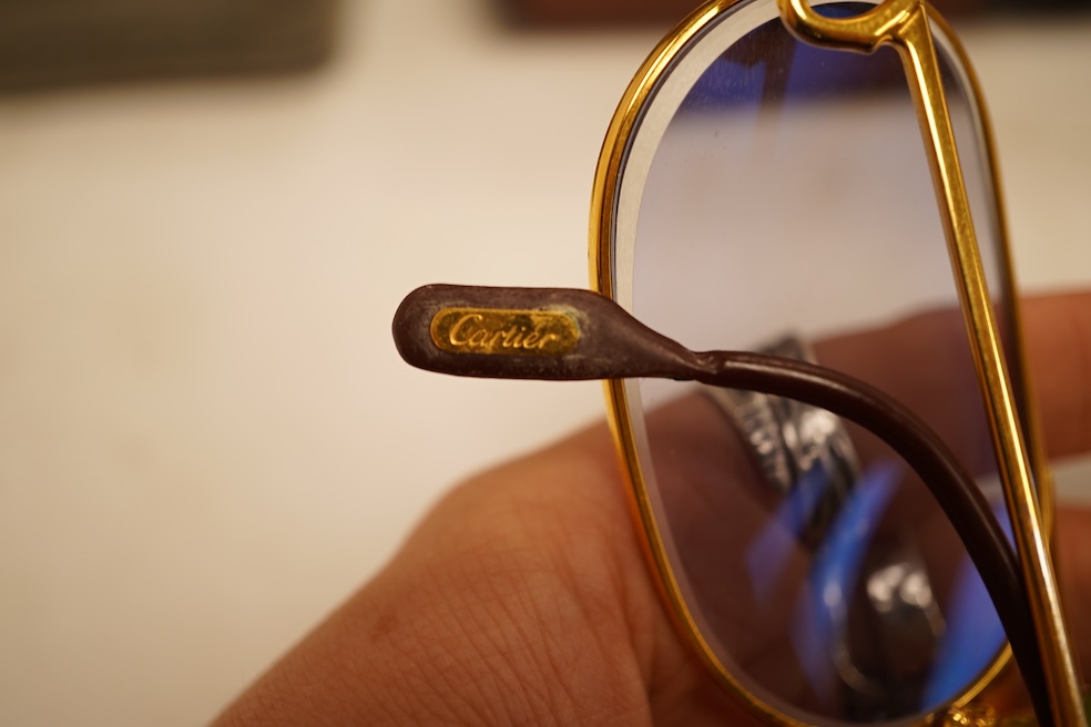 Two pairs of vintage Cartier gilt metal glasses, a pair of Gucci glasses and another